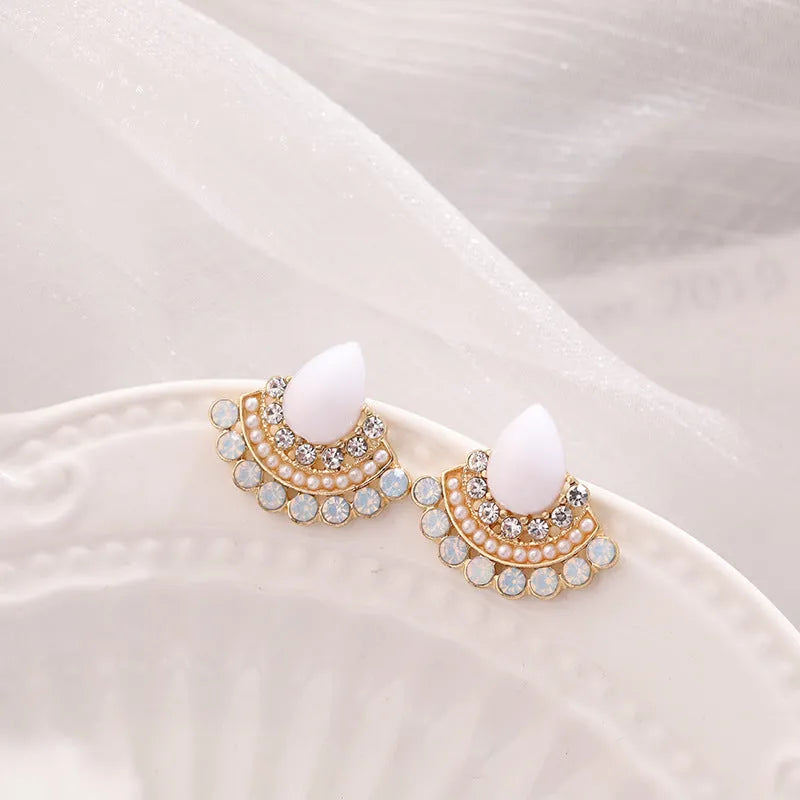 Silver fan-shaped drop earrings with rhinestone and opal geometric design on white background