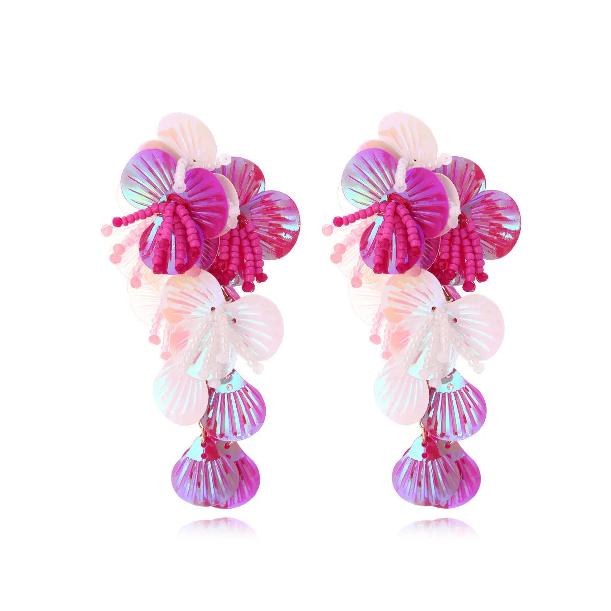 Handmade exaggerated floral earrings with colourful string beads and leaves on a purple background.
