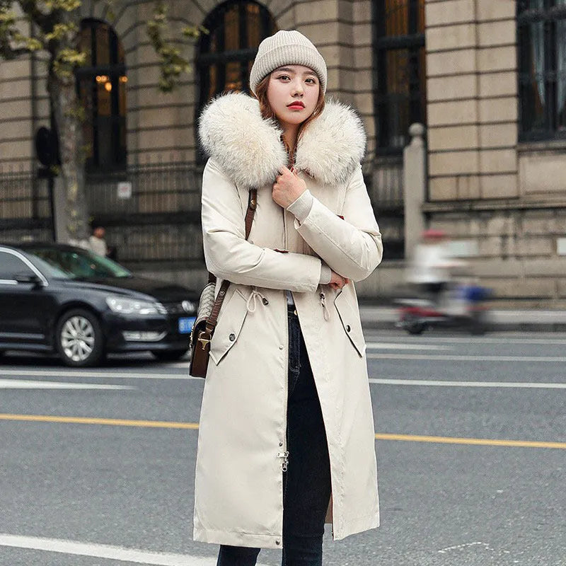 Women's long beige trench coat with fleece lining on a hanger, showing its extended length and elegant style.