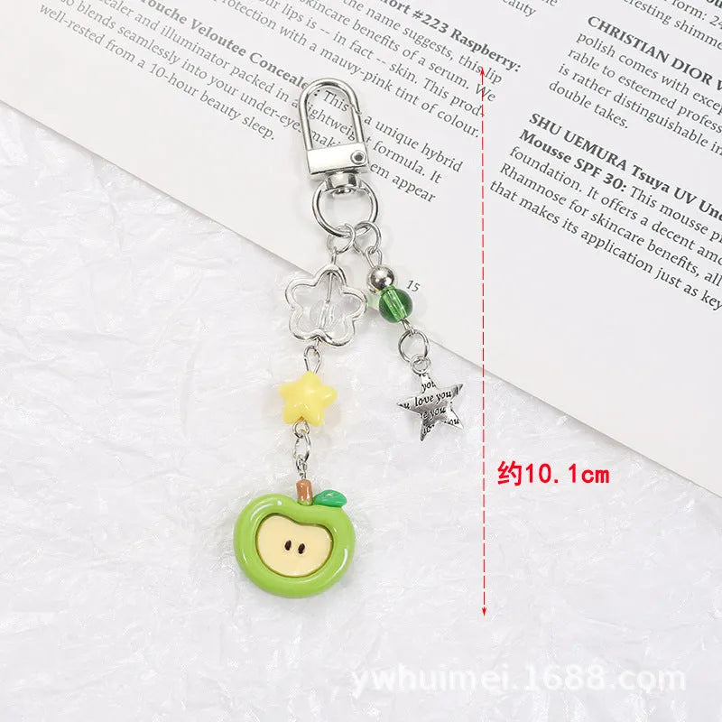 Plastic resin fruit charm keychain with removable rope in strawberry, green apple, and red apple designs.