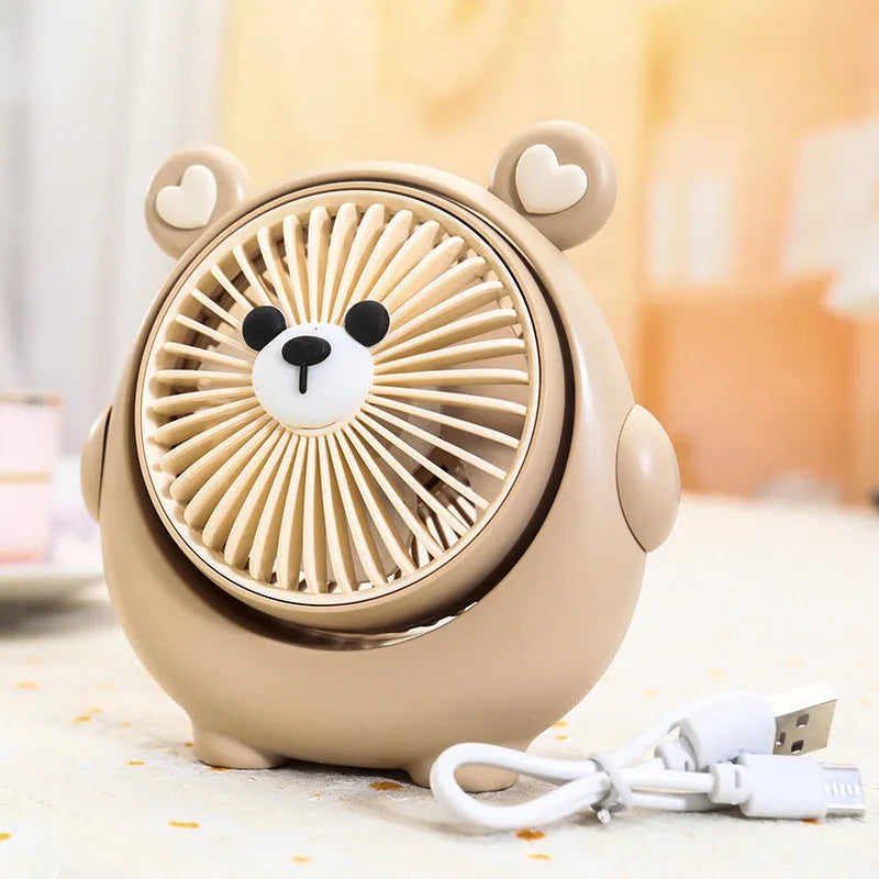 USB desktop electric fan in one of six colours including bear brown and puppy designs on a desk.