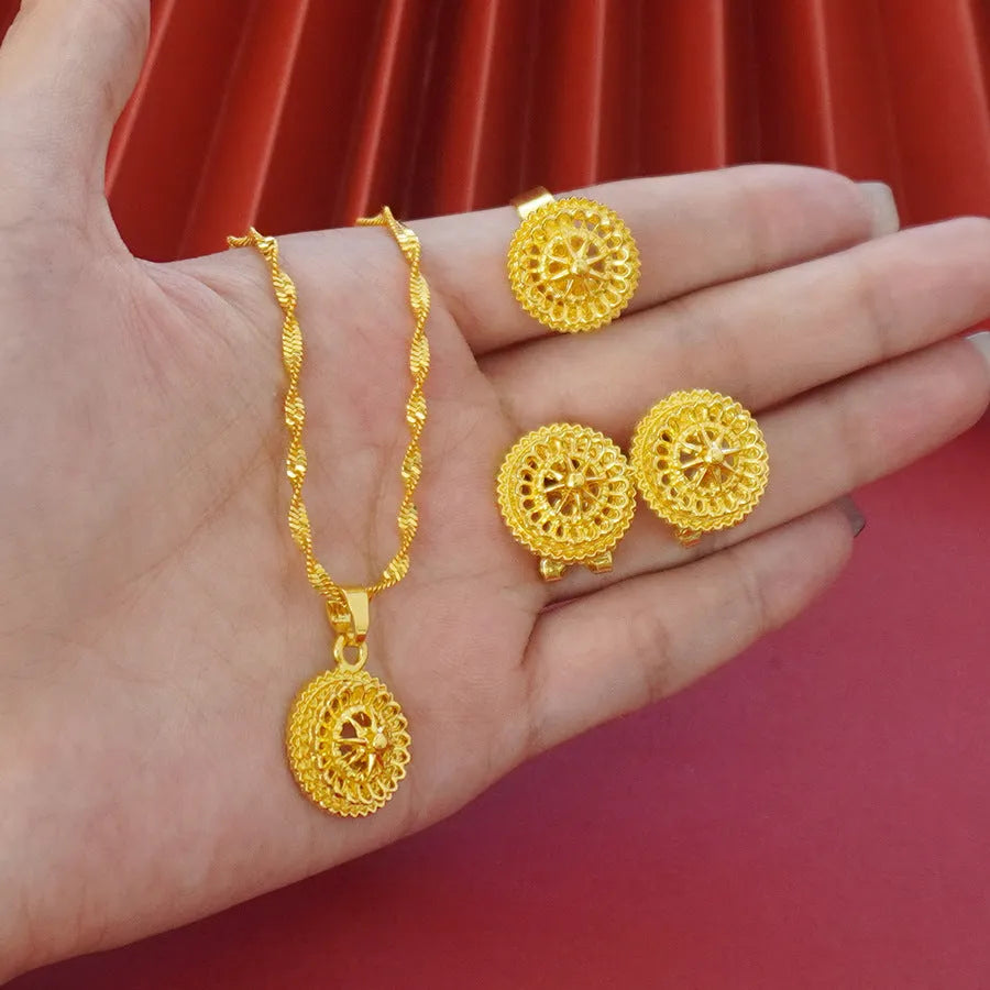 Gold-plated three-piece jewelry set showing necklace, earrings, and ring with a detailed flower design pendant.