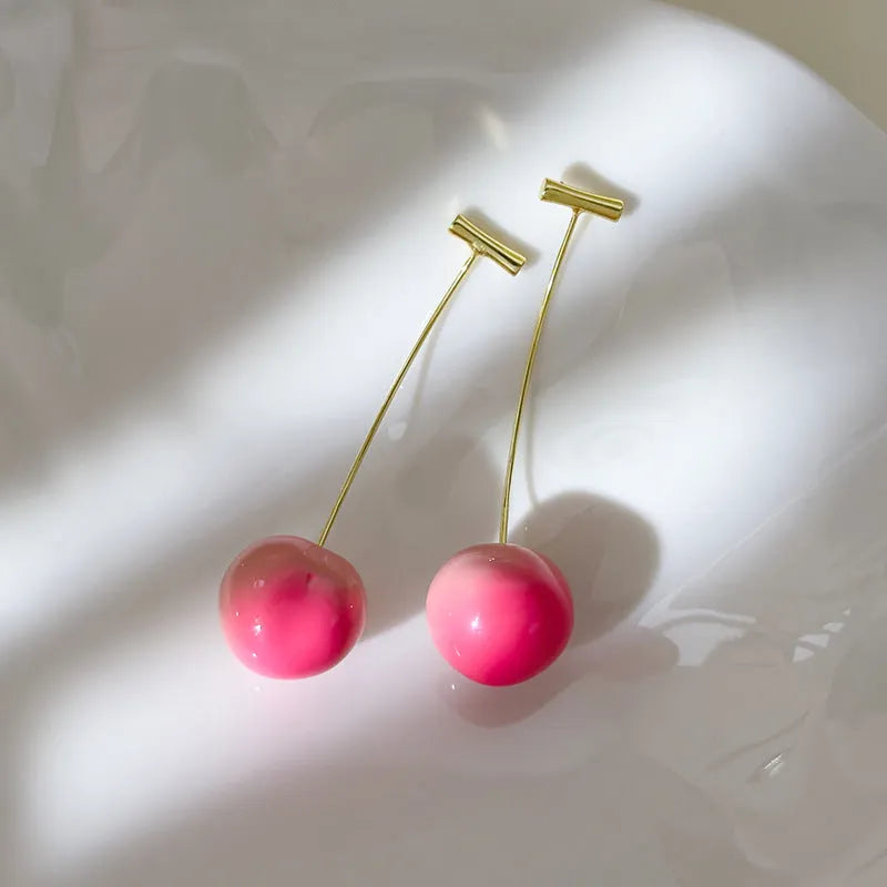 Acrylic peach-shaped dangle earrings with copper findings, shown in small and large size variations.