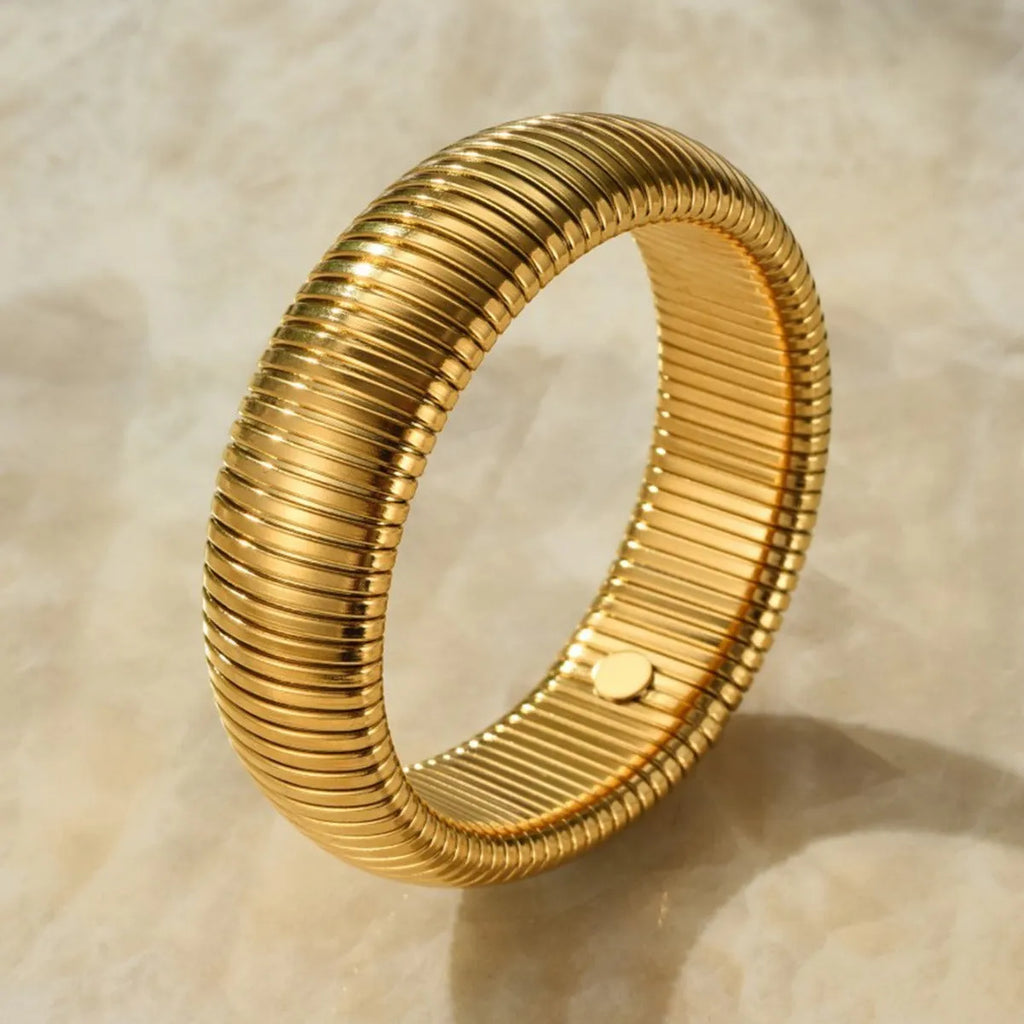 Gold titanium steel women's bracelet with elastic band and vertical stripe ring pattern, shown at 2cm width.