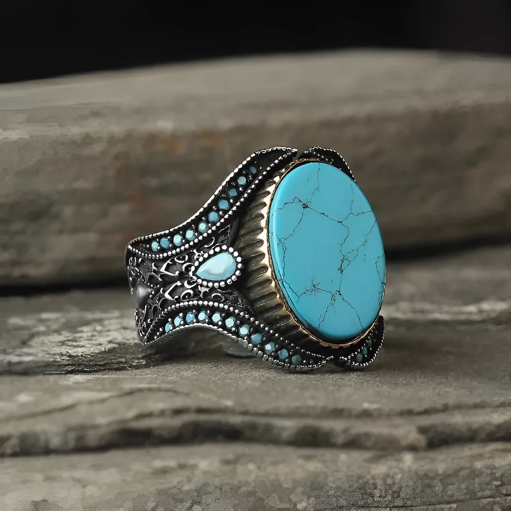 Men's antique silver alloy ring with a round turquoise-coloured centre on a grey background.