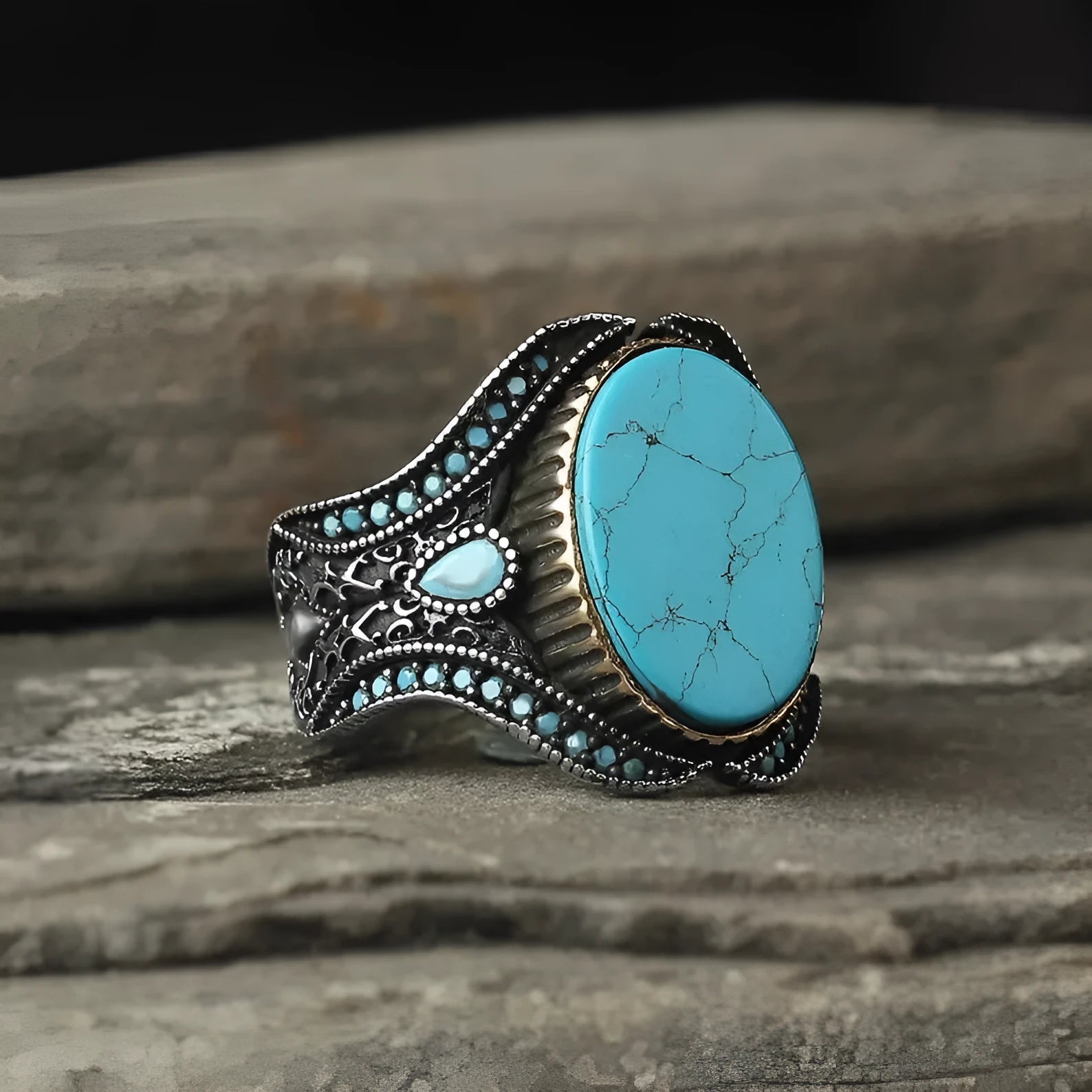 Men's antique silver alloy ring with a round turquoise-coloured centre on a grey background.