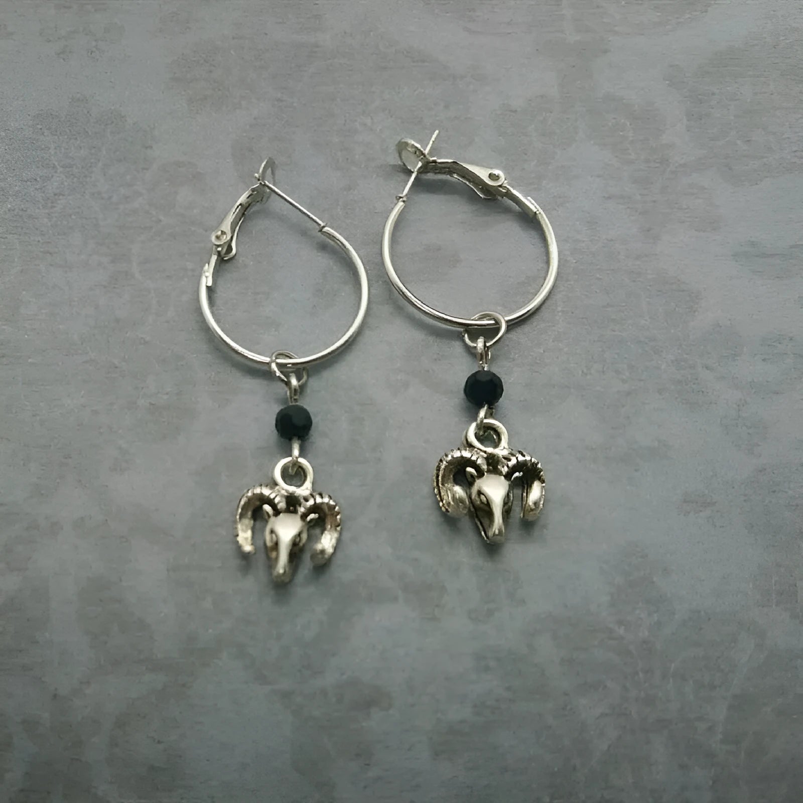 A pair of silver round hoop earrings for women with Tibetan antelope and Western style influences.