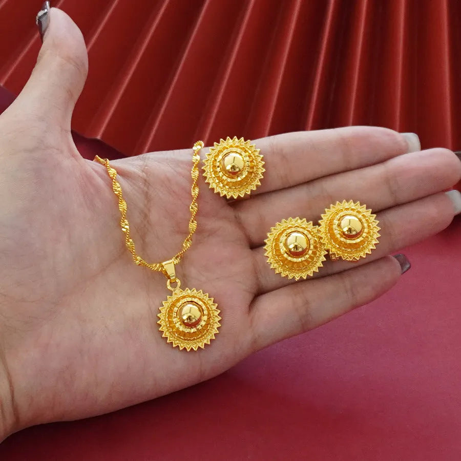 Gold-plated three-piece jewelry set showing necklace, earrings, and ring with a detailed flower design pendant.