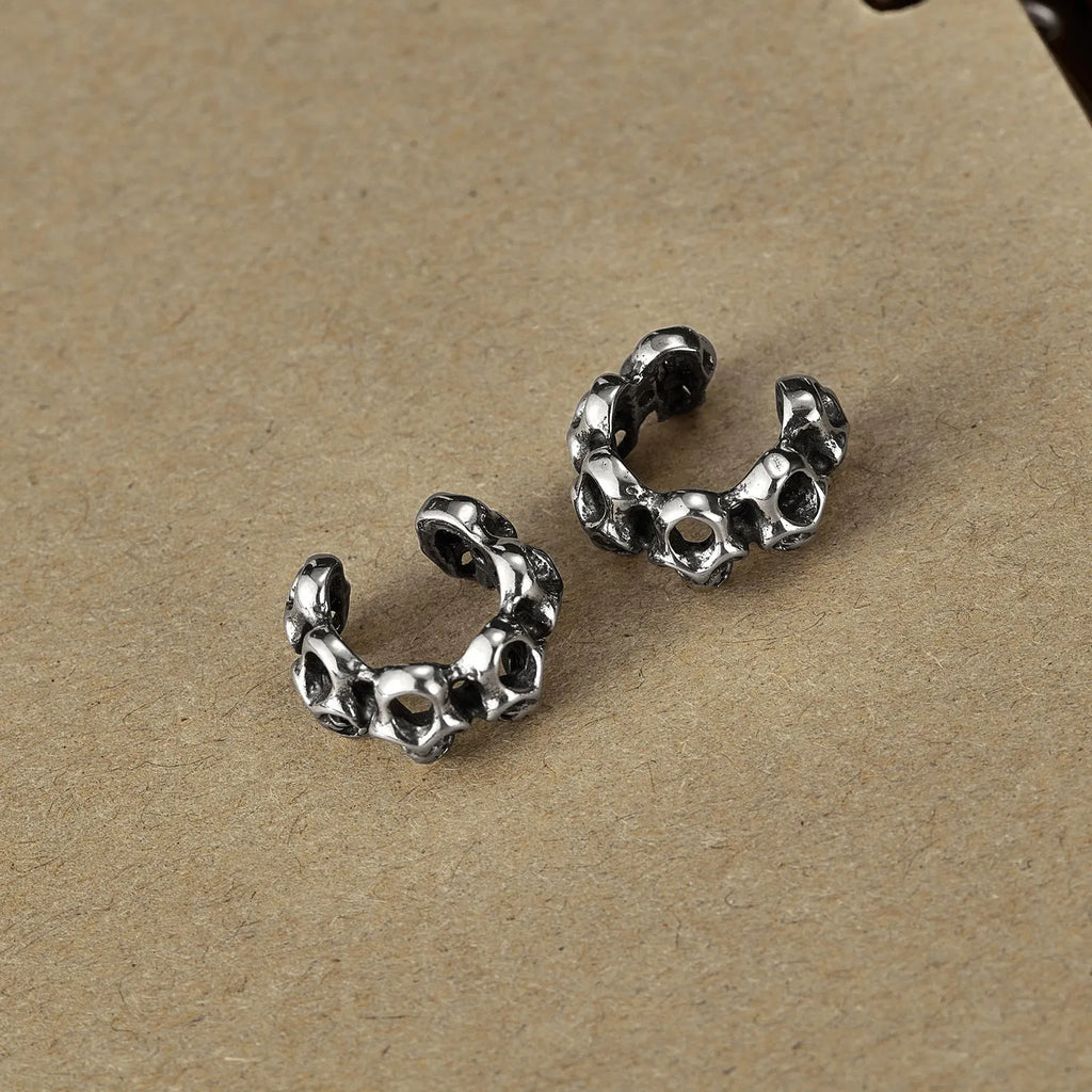 Steel hollow skull earrings with geometric design and ear clip fitting