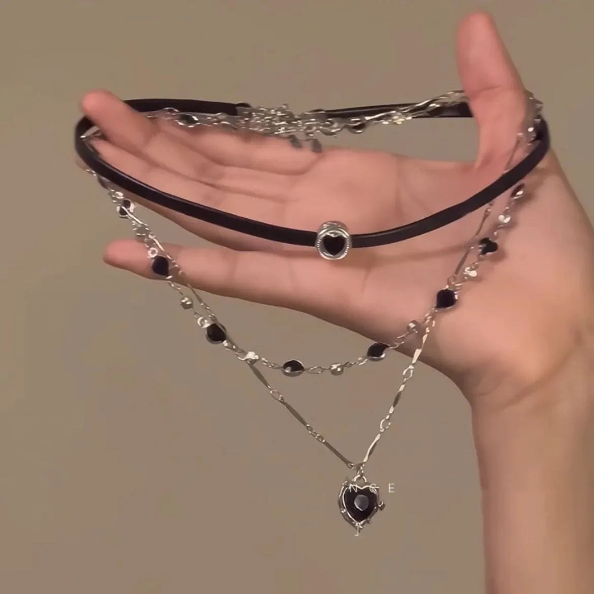 Women's twin necklace set showing double-layer leather heart and single-layer love designs with alloy and crystal elements