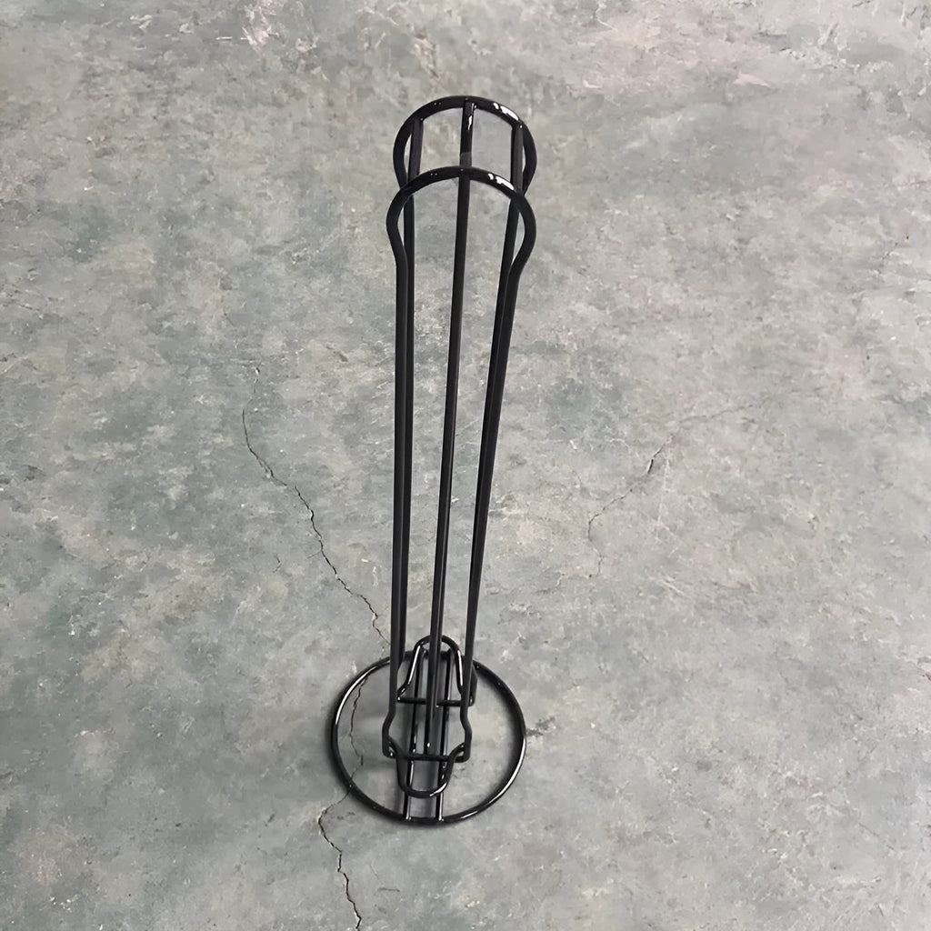 Black iron coffee capsule storage rack holding multiple pods on display shelves.