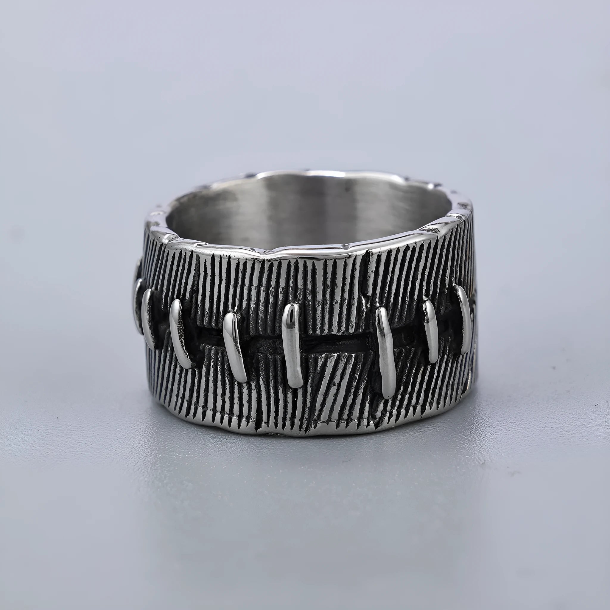 Dark punk geometric U-shaped double ring in titanium steel on a solid background