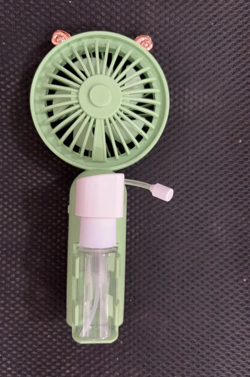 Plastic USB desk fan with a flexible nozzle in apricot colour on a wooden desk.