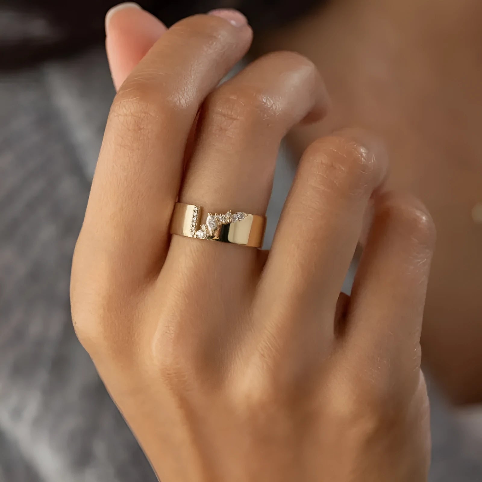 Gold electroplated zircon ring on finger showing shining finish and decorative detail