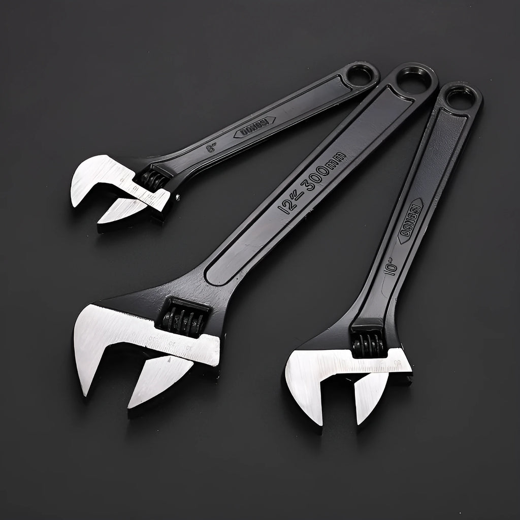 Black stainless steel adjustable open-end wrench on a workbench, showing size markings and ergonomic handle.