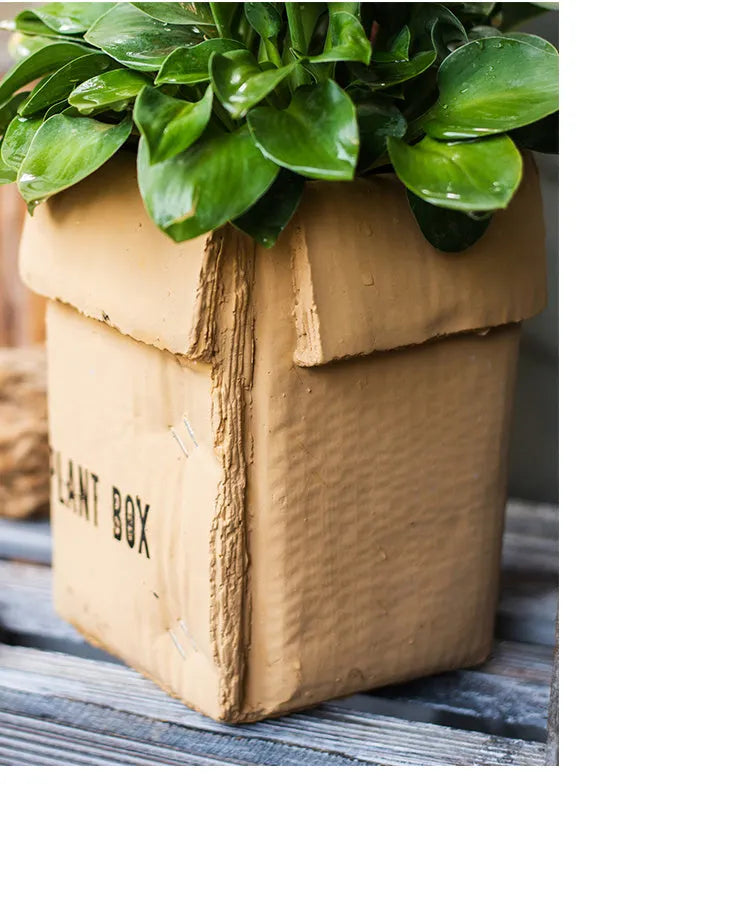 Cement flowerpot styled as a brown paper box with drainage hole for indoor balcony gardening