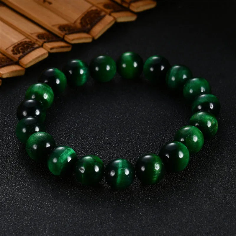 Green tiger eye stone bracelet with geometric beads on a wrist