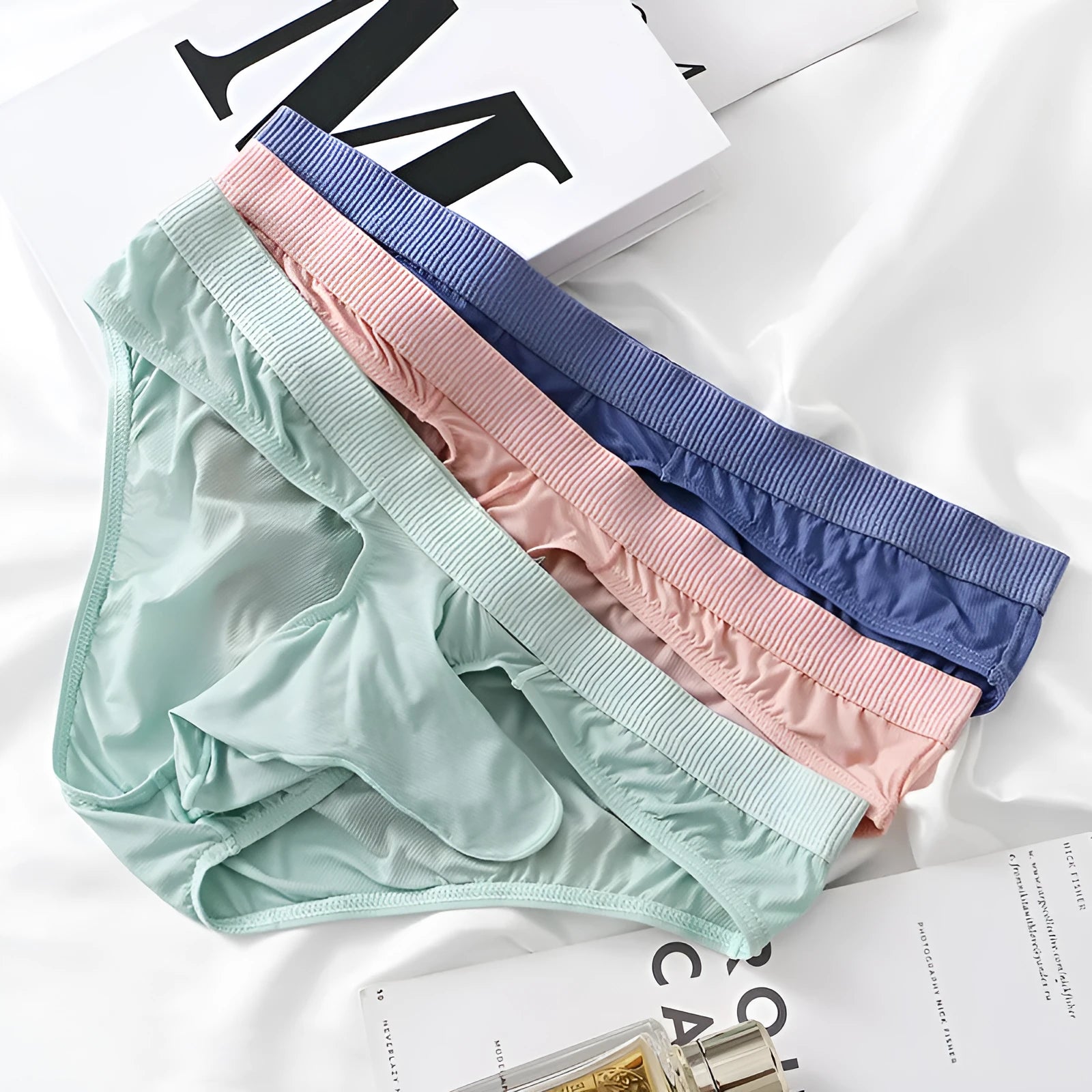 Ice silk men's low waist briefs underwear shown in multiple colours including black, grey, purple blue, light green, and pink.