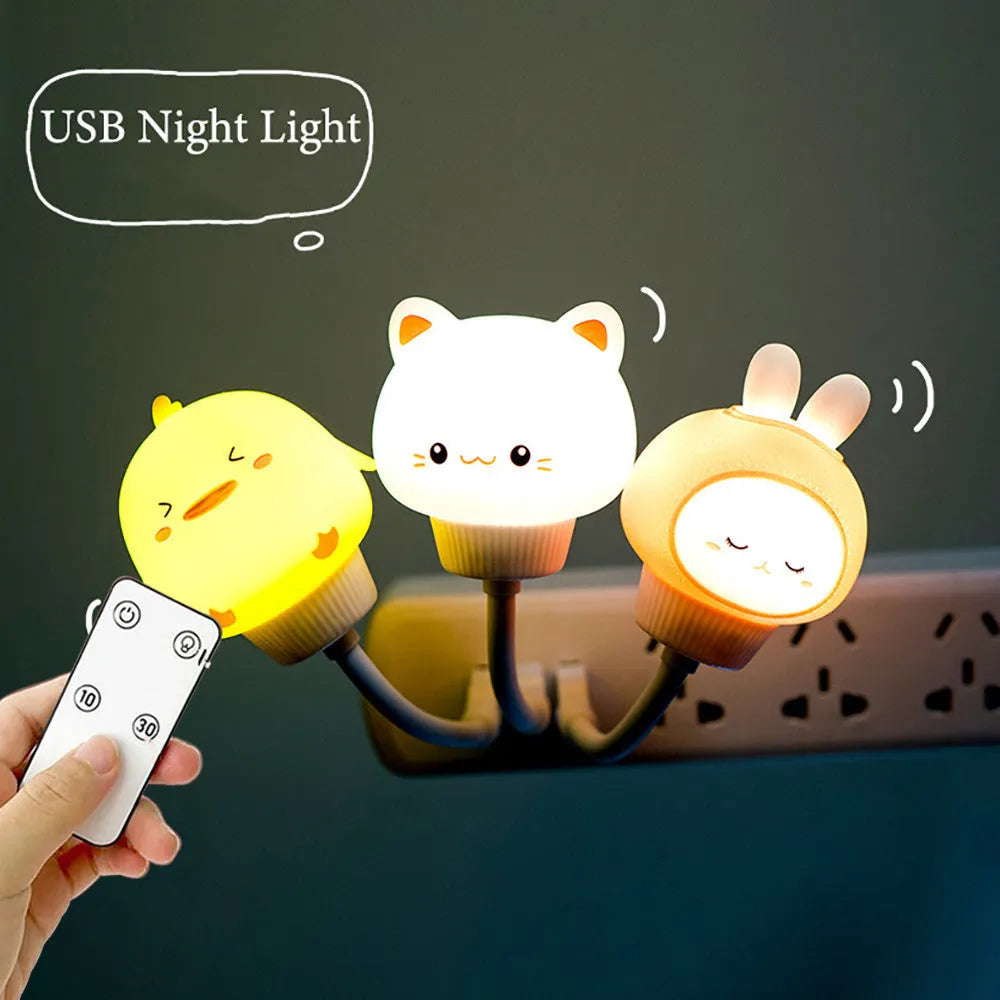 Small cartoon bear-shaped USB night light with remote control on a bedside table.