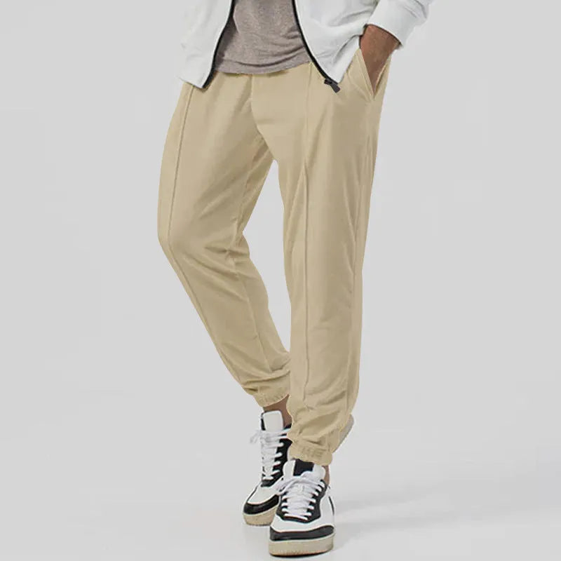 Men's grey loose-fit tapered track sweatpants with a straight leg on a neutral background.
