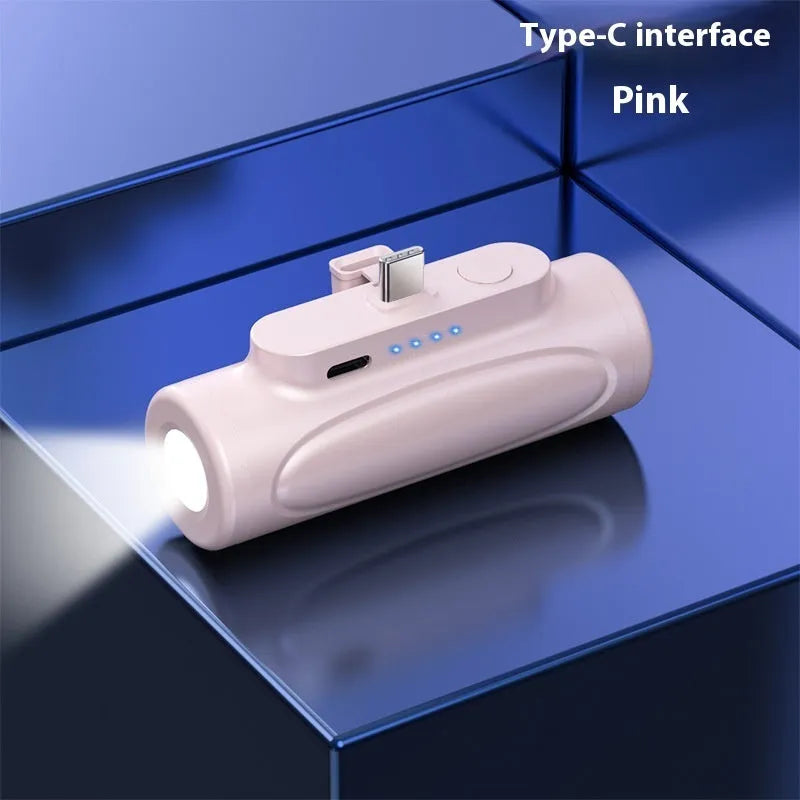 Black and pink creative power bank with integrated LED flashlight showing scale and port options.