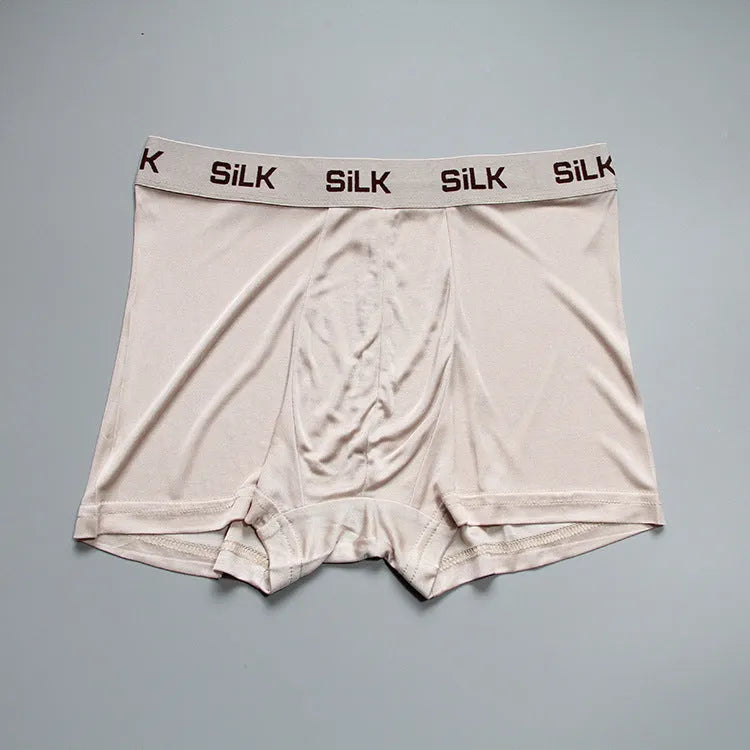 Man wearing loose fit navy blue silk shorts with a mid waist design.