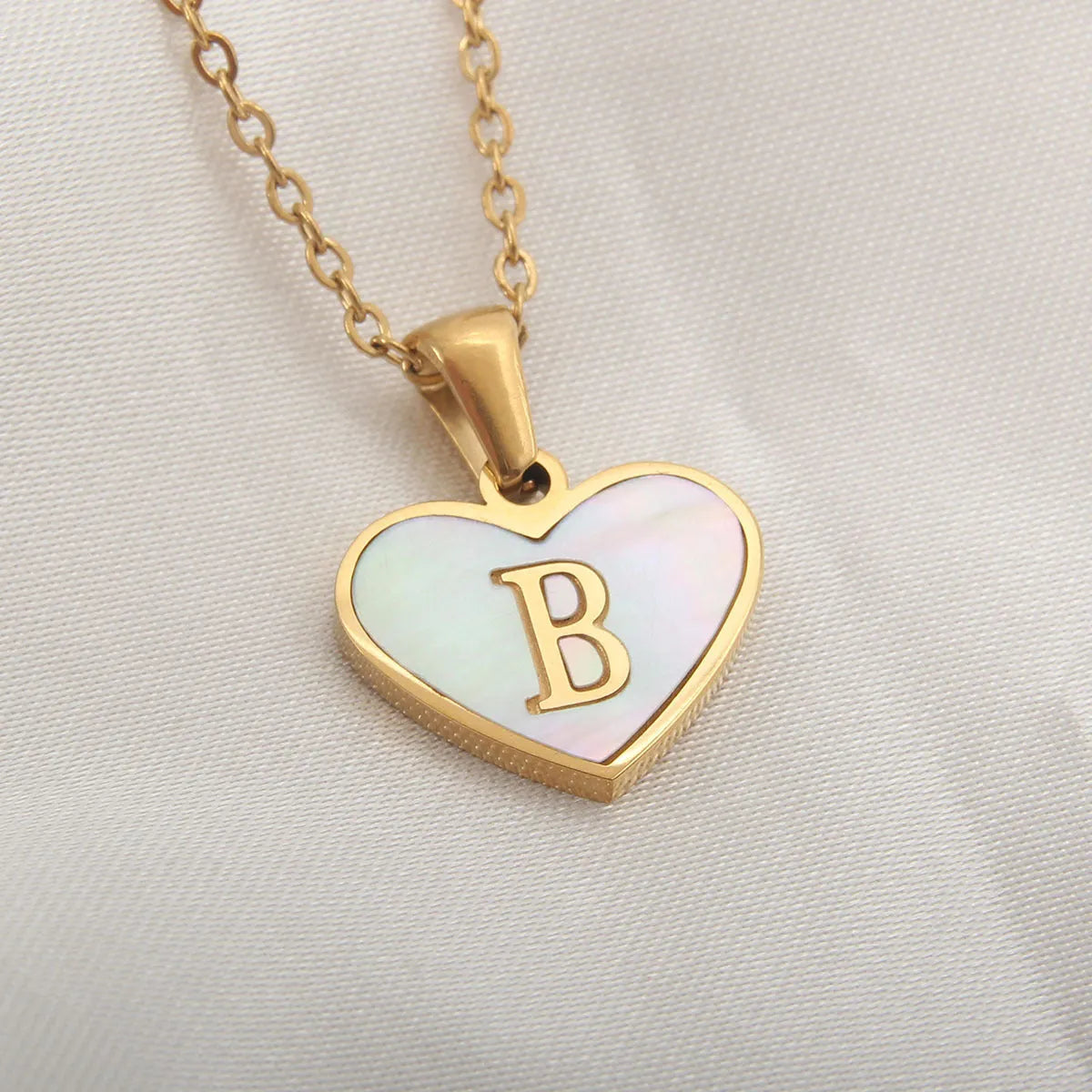 Gold plated heart-shaped necklace with white shell pendant on adjustable stainless steel chain