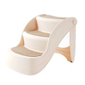 Foldable plastic pet stairs for small dogs on a carpet next to a sofa.