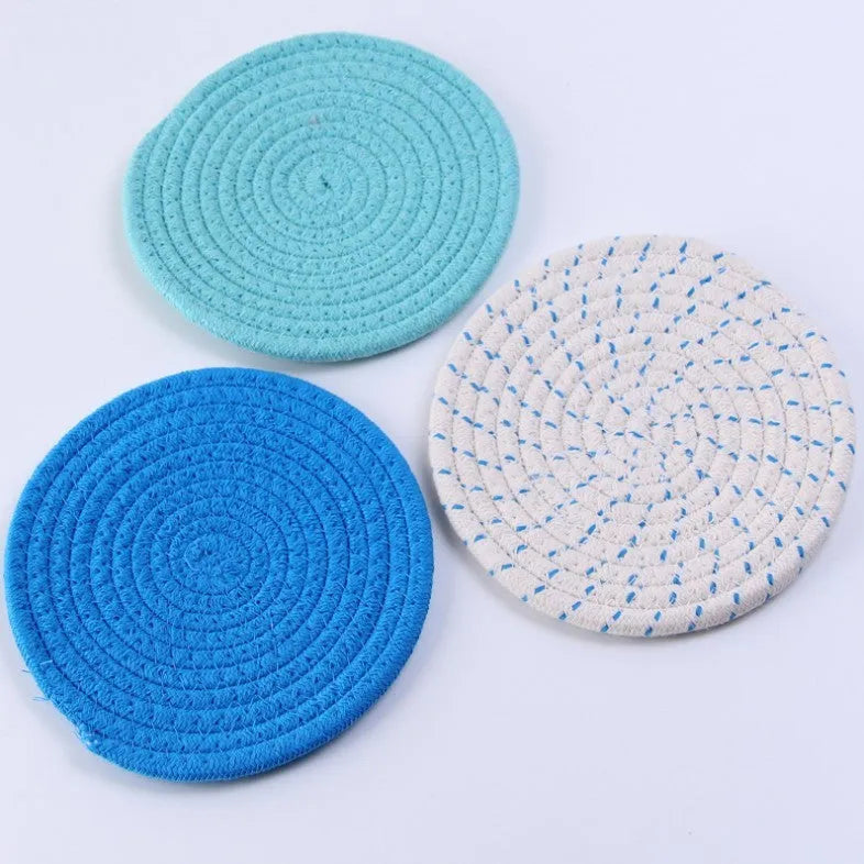 Set of three round grey cotton cord coasters on a wooden table, each 18cm in diameter.