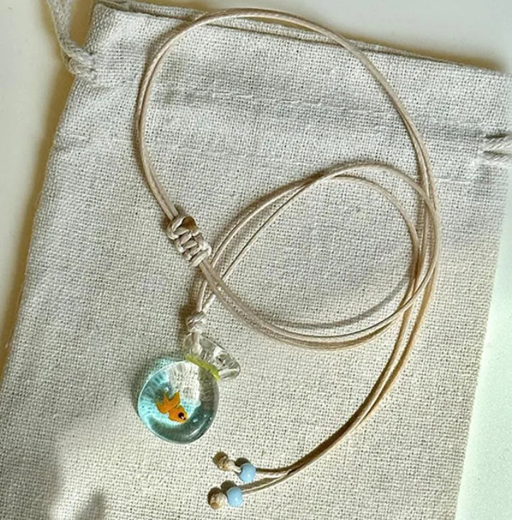 Women's necklace with Small Fish Lucky Bag glaze pendant on a cotton linen chain.