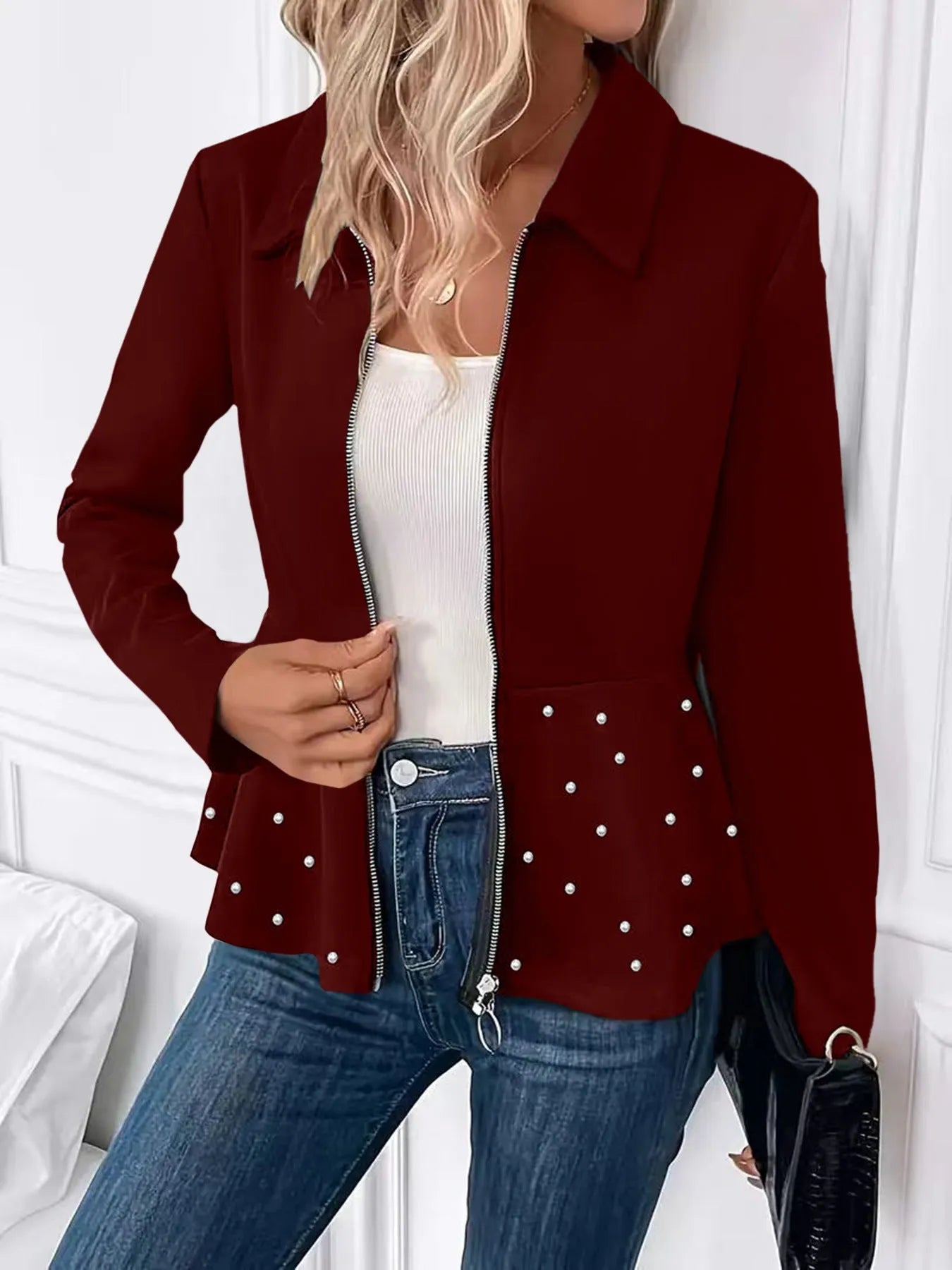 Women's loose black coat with beaded zipper and ruffled hem, shown on a hanger.