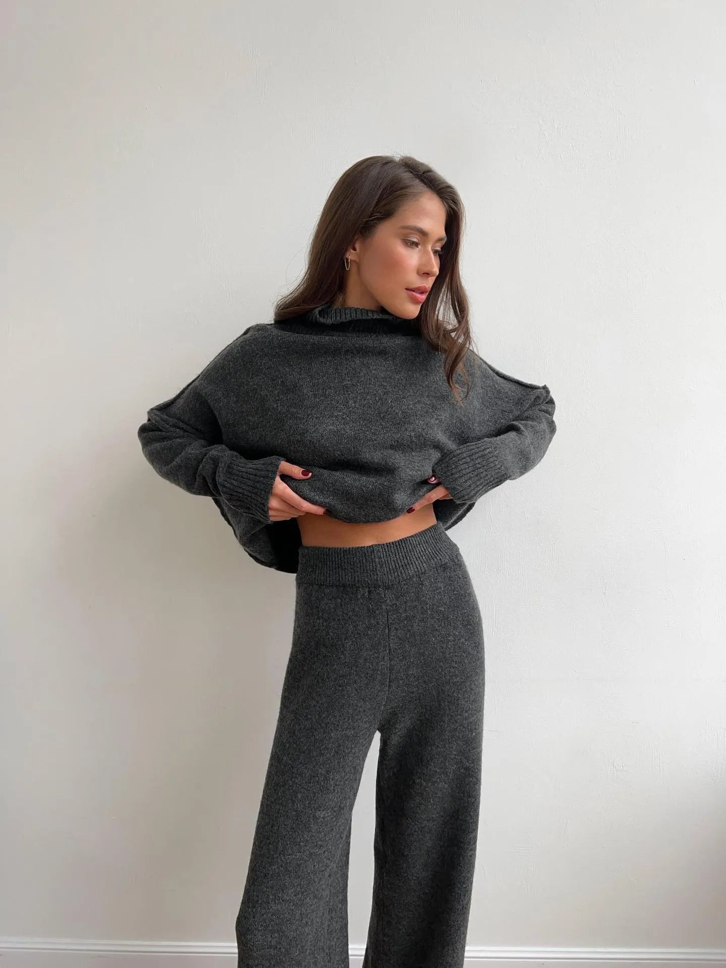 Women's dark grey side-slit sweater and trousers suit set on a hanger
