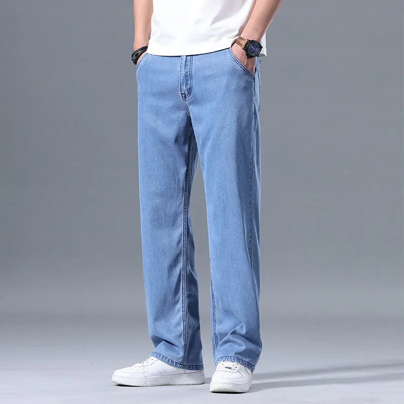 Men's loose fit straight leg lyocell jeans in light blue on a neutral background.