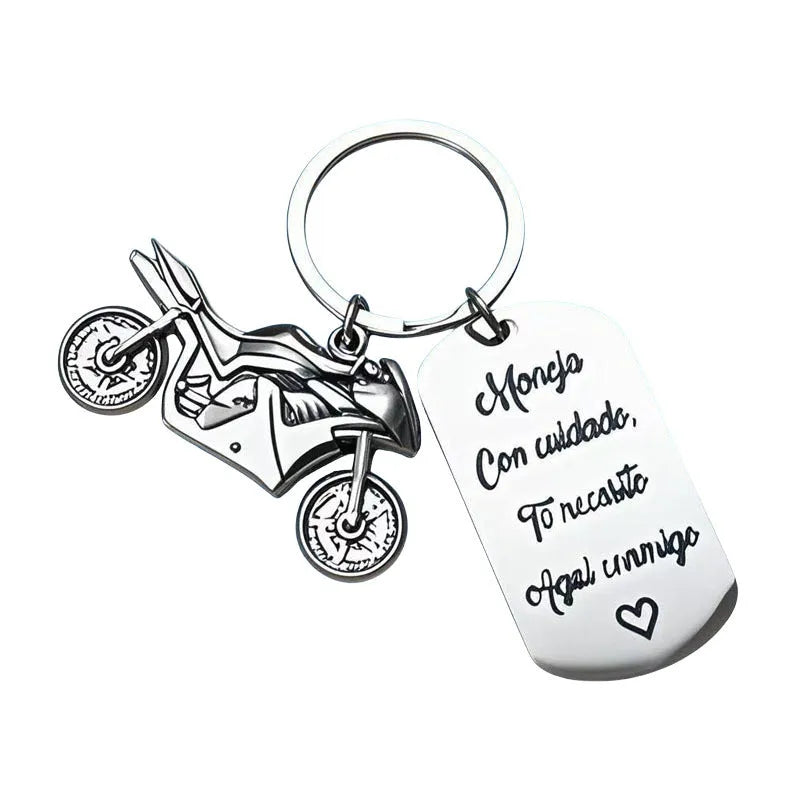 Stainless steel motorcycle keychain with inspirational design on a flannel bag.