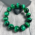 Green tiger eye stone bracelet with geometric beads on a wrist