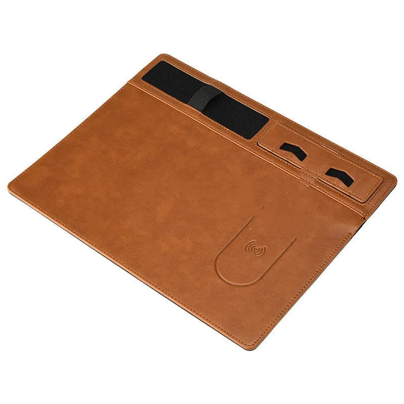 Black wireless charging mouse pad with phone holder on a desk, showing USB cable.