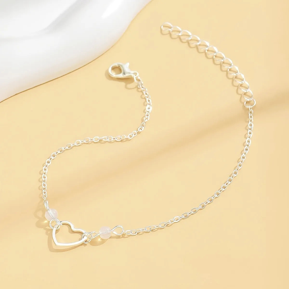 Gold and silver women's anklet with heart-shaped pendant charm and adjustable length