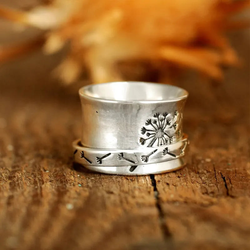 Silver tone floral fashion ring with rotatable flower element on alloy band