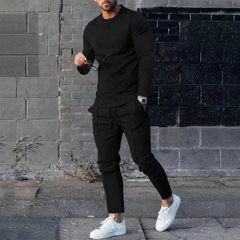 Men's light grey polyester two-piece suit with long sleeve round neck T-shirt and matching trousers laid flat.