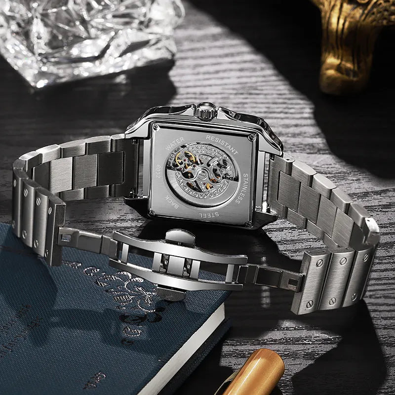 Square silver men's automatic watch with diamond-studded bezel on a black leather strap.