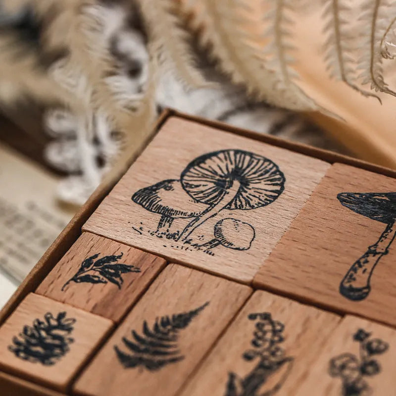 Set of seven wooden craft stamps for DIY journal decoration in stars and moon or plant catalog designs.