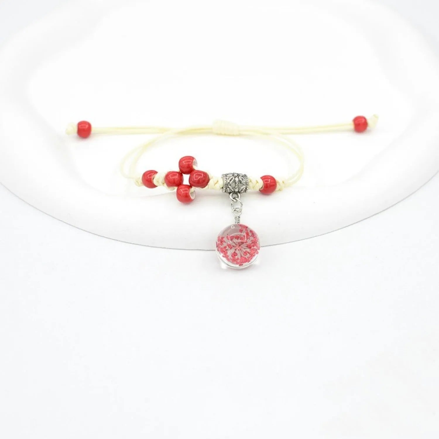 Close-up of a hand-woven glass bracelet with large 1.4 cm beads containing real dried flowers in multiple colour options.