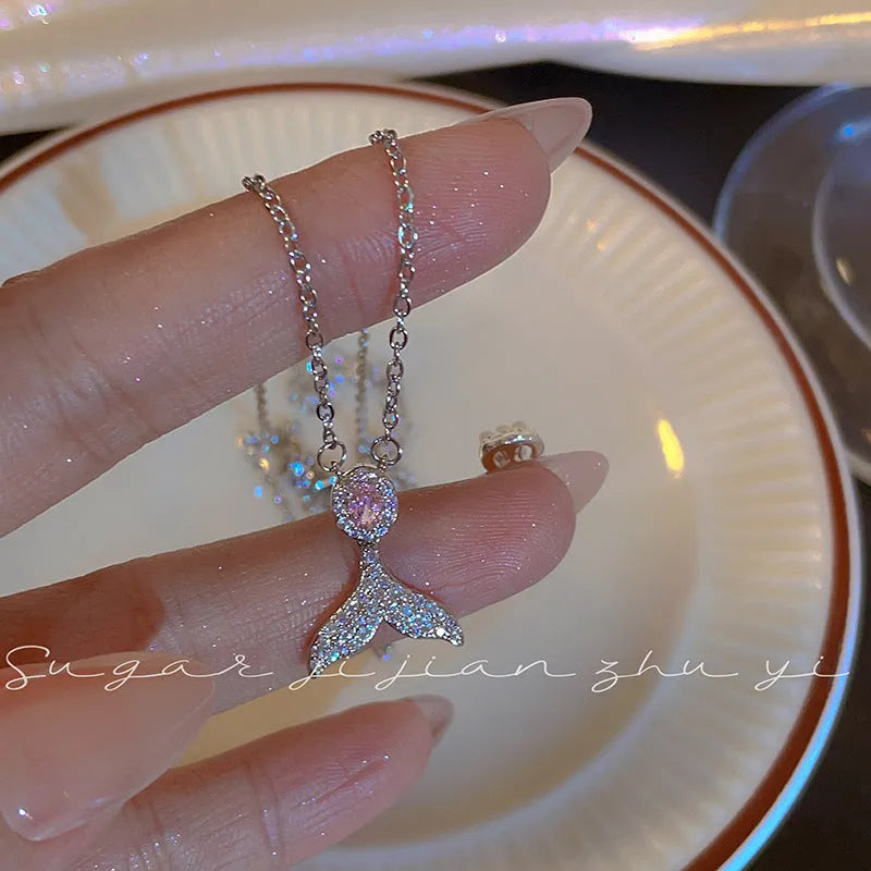 Close-up of a women's sterling silver fishtail pendant necklace on an adjustable O-ring chain.