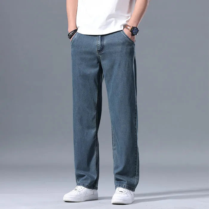Men's loose fit straight leg lyocell jeans in light blue on a neutral background.