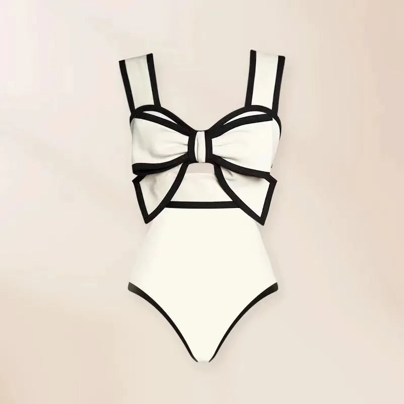 Female one-piece swimsuit with round skirt and bow detail in black or white polyester fabric for swimming and beach wear