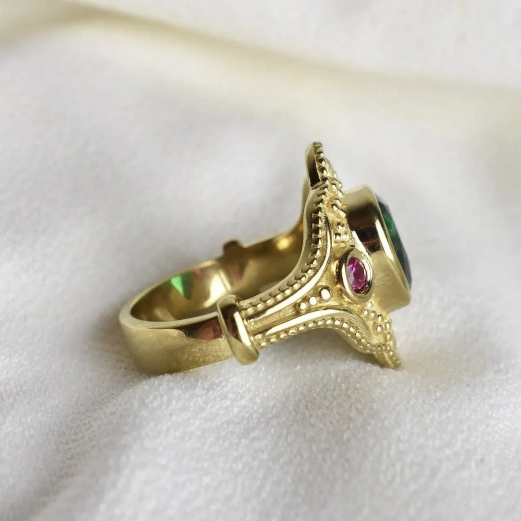 Geometric gold-coloured women's ring with an electroplated finish on a grey background.