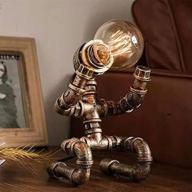 Iron pipe industrial retro style table lamp in vintage colour on a wooden desk.