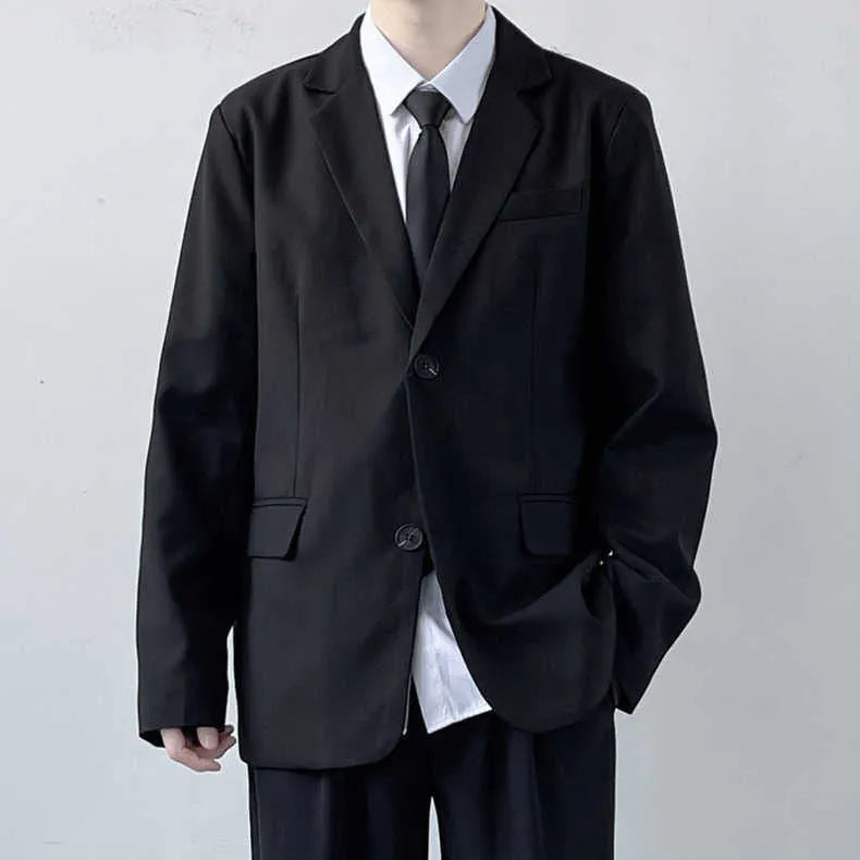 Plus size man modelling a loose fit black suit jacket and trousers with a white shirt and tie.