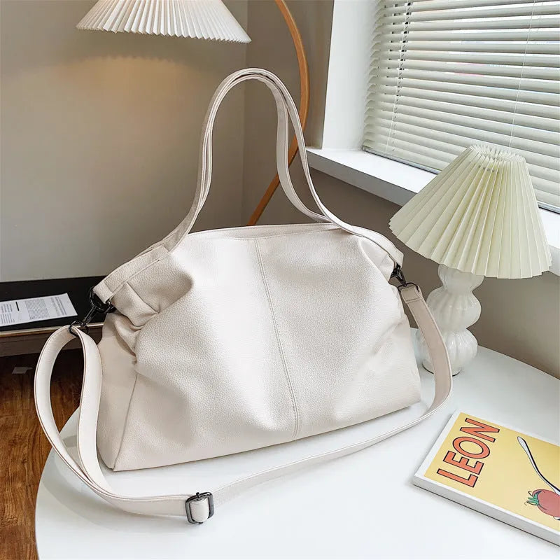 Large soft surface black messenger bag with a shoulder strap and zipper opening.