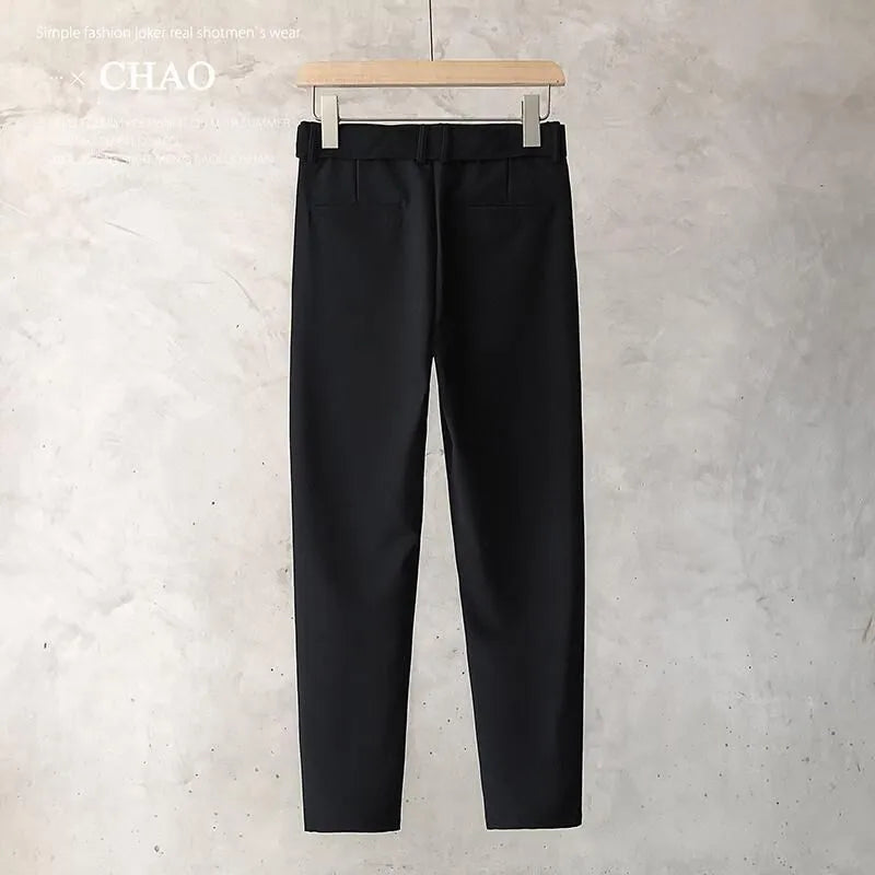 Boy wearing slim straight wool trousers in a neutral colour, showcasing the tapered fit and straight leg opening.